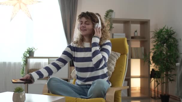 一位成年女性使用耳机进行在线引导冥想练习心神瑜珈 在家中闭上双眼真正的人自我保健概念慢动作 — 图库视频影像