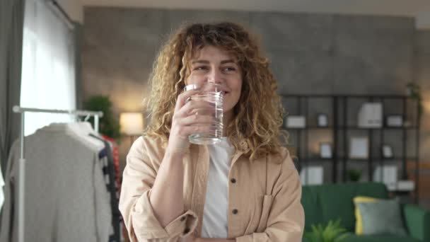 人の女性の美しい大人の女性は水のカーリー ヘアのガラスと家で幸せな笑顔健康なライフスタイルの水分補給の概念 — ストック動画