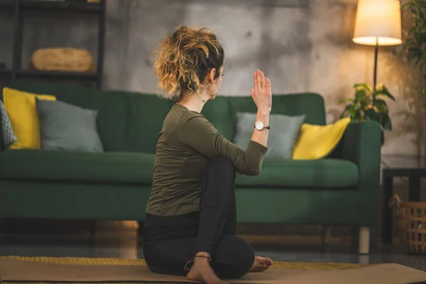 女人在家里客厅的垫子上练习瑜伽 — 图库照片