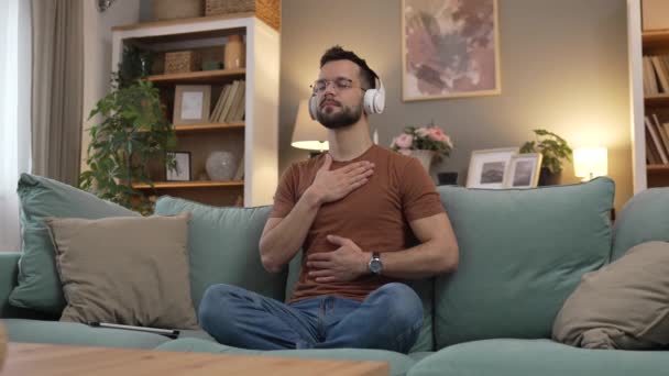 Mann Mit Kopfhörer Praktiziert Geführte Meditation Yoga Selbstpflege Hause — Stockvideo