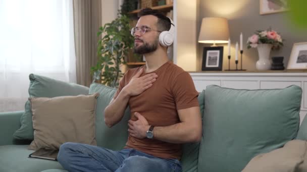 Mann Mit Kopfhörer Praktiziert Geführte Meditation Yoga Selbstpflege Hause — Stockvideo