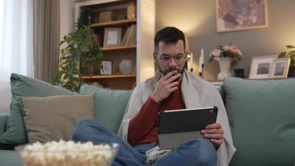 一名成年男子在家中沙发床上用数码平板电脑观看视频 — 图库视频影像