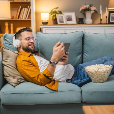 Bir yetişkin erkek beyaz erkek, video videolarını internetten izliyor ya da video çekiyor.