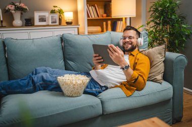 Bir yetişkin erkek beyaz erkek, video videolarını internetten izliyor ya da video çekiyor.