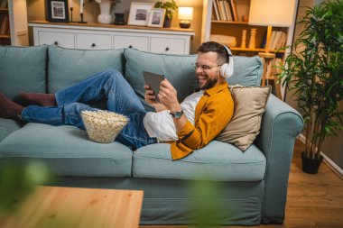 Bir yetişkin erkek beyaz erkek, video videolarını internetten izliyor ya da video çekiyor.