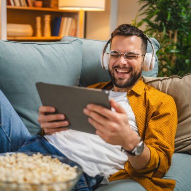 Bir yetişkin erkek beyaz erkek, video videolarını internetten izliyor ya da video çekiyor.