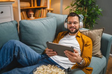 Bir yetişkin erkek beyaz erkek, video videolarını internetten izliyor ya da video çekiyor.