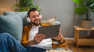 Bir yetişkin erkek beyaz erkek, video videolarını internetten izliyor ya da video çekiyor.