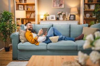 Bir yetişkin erkek beyaz erkek, video videolarını internetten izliyor ya da video çekiyor.