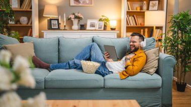 Bir yetişkin erkek beyaz erkek, video videolarını internetten izliyor ya da video çekiyor.