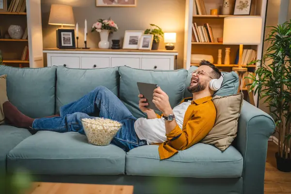 Bir yetişkin erkek beyaz erkek, video videolarını internetten izliyor ya da video çekiyor.