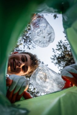 Pov bakış açısı çantanın içinden genç gönüllü gençler doğanın çevre bilincinden plastik atık topluyor ve konsepti geri dönüştürüyor