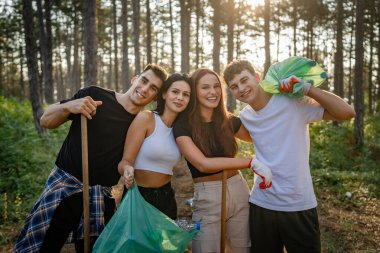 Gönüllü arkadaş portresi yaz günü yavaş çekimde çöpleri ve temiz orman doğasını toplamaya hazırlanıyor.