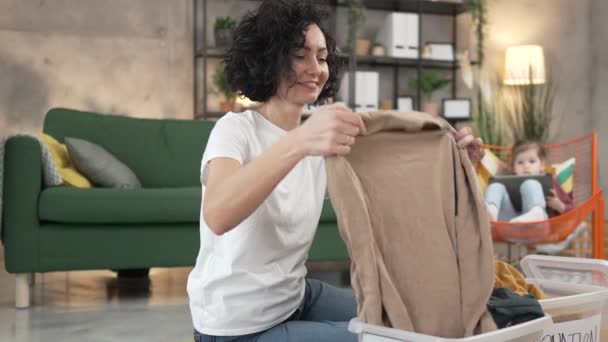 寄付の遅い動きのための服のワードローブを分類する自宅の大人の慎重な女性 — ストック動画