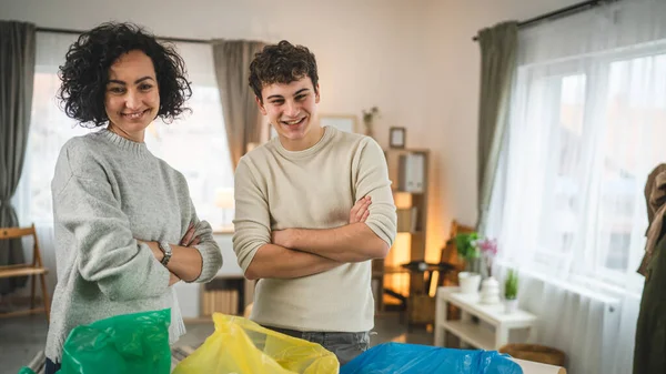 母親と息子の女性と10代の男の家族は 持続可能な生活のコンセプトを袋に廃プラスチック紙とガラスを分類する家庭でリサイクルします — ストック写真
