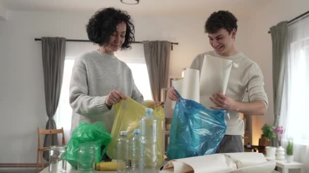 母亲和儿子妇女和青少年家庭在家里循环利用 整理废纸和废玻璃 打包可持续生活理念 — 图库视频影像