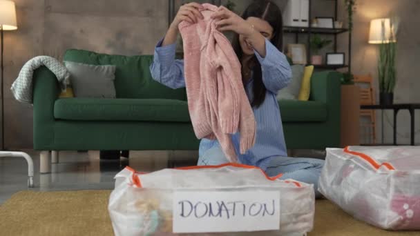 Μια Γυναίκα Καυκάσιος Ενήλικας Στο Σπίτι Επιλέγει Ρούχα Για Φιλανθρωπική — Αρχείο Βίντεο