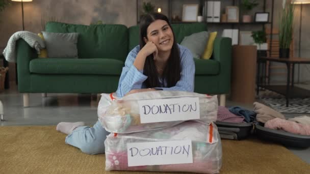 Одна Женщина Взрослая Кавказка Дома Выбирает Одежду Благотворительного Пожертвования — стоковое видео