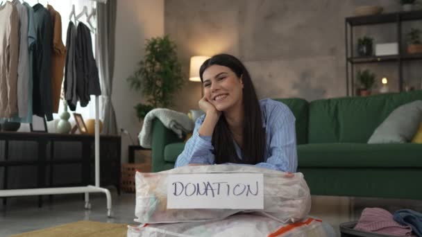 Одна Женщина Взрослая Кавказка Дома Выбирает Одежду Благотворительного Пожертвования — стоковое видео