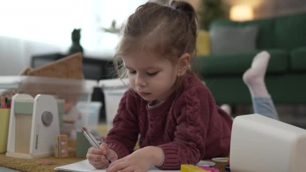 Одна Кавказская Девочка Играет Полу Дома Рисовать Ручкой — стоковое видео