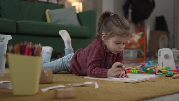 ワンガールの慎重な幼児はペンで家のドローで床で遊びます — ストック動画