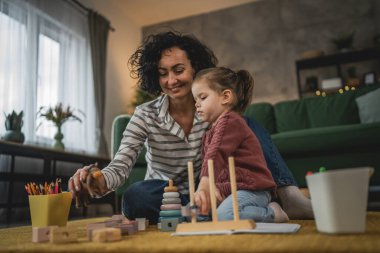Anne ve kız çocuğu evde oynuyorlar.