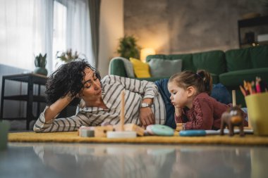 Anne ve kızı evde online video izlemek için dijital tablet kullanıyorlar.