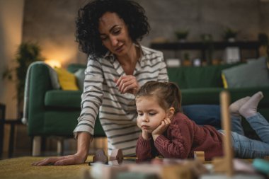 Anne ve kızı evde online video izlemek için dijital tablet kullanıyorlar.