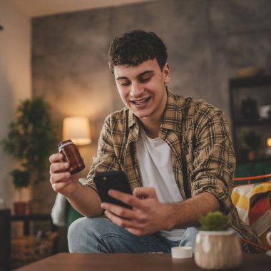 Genç bir adam doktorla online istişare yapıyor. İlaç şişesi ilave ilaç tedavisi görüyor.