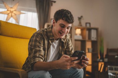 Bir adam ilaç tutuyor. İlaç şişesi hapları. Cep telefonunda etiketi yazıyor.