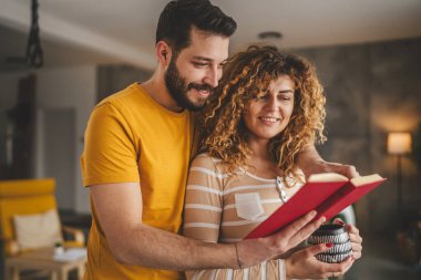 Evde kitabı olan beyaz erkek ve kadın portresi.