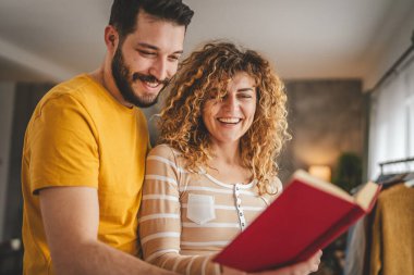 Evde kitabı olan beyaz erkek ve kadın portresi.