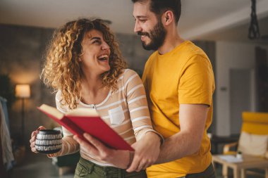 Evde kitabı olan beyaz erkek ve kadın portresi.