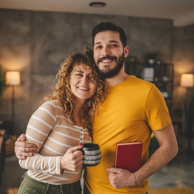 portrait of man and woman caucasian adult couple with book at home clipart