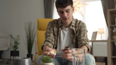 Bir adam ilaç tutuyor. İlaç şişesi hapları. Cep telefonunda etiketi yazıyor.