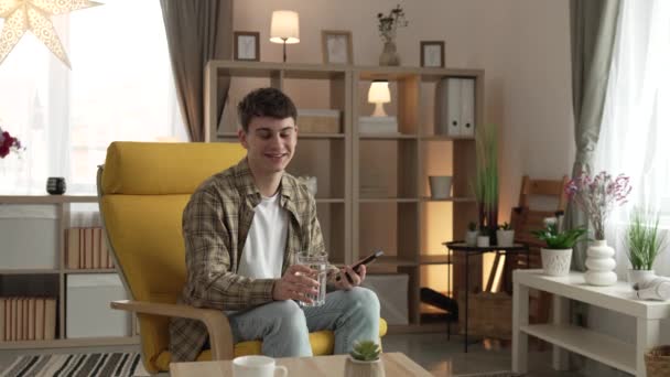 年轻的高加索男性青少年在家里拿着杯子喝水的画像 — 图库视频影像