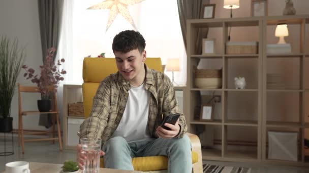 年轻的高加索男性青少年在家里拿着杯子喝水的画像 — 图库视频影像