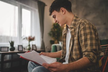 Genç beyaz erkek, evde öğrenim görüyor. Dersi ya da sınavı kendi başına hazırla. Gerçek insanlar boşluğu doldurur.