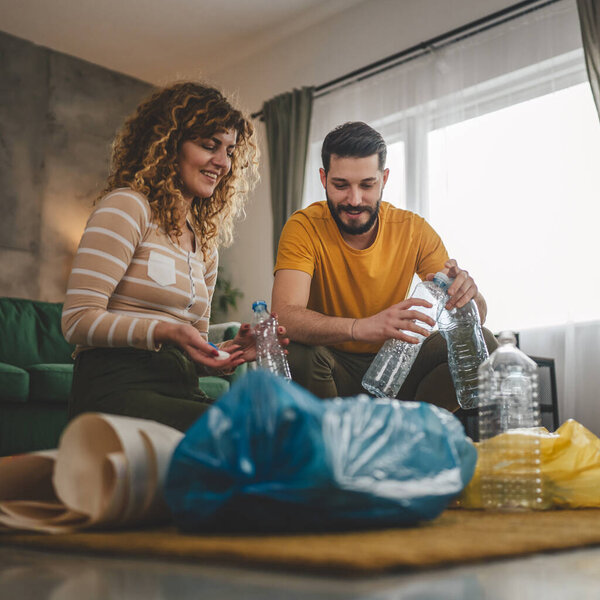 муж и жена женщина и мужчина семья перерабатывать дома сортировки отходов пластиковой бумаги и стекла в зеленый, желтый и синий мешки устойчивой концепции жизни
