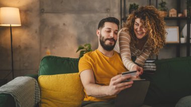 Kafkas erkek ve kadın karı koca ya da sevgili dijital tablet ve kredi kartı alışverişi kullanıyor. İnternetten bir şeyler satın alıyor ya da ödemeyi ev halkının e-ticaretinden yapıyor.
