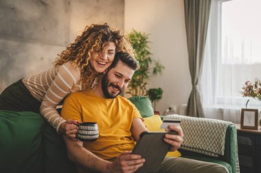 Kafkas erkek ve kadın karı koca ya da sevgili dijital tablet ve kredi kartı alışverişi kullanıyor. İnternetten bir şeyler satın alıyor ya da ödemeyi ev halkının e-ticaretinden yapıyor.