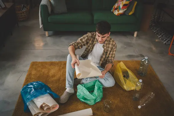 Genç Bir Adam Evde Plastik Kağıt Cam Atıklarını Geri Dönüştürüyor — Stok fotoğraf