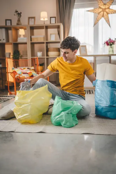 Ένας Άνδρας Νεαρός Ενήλικας Ανακυκλώνει Στο Σπίτι Απορρίμματα Πλαστικού Χαρτιού — Φωτογραφία Αρχείου