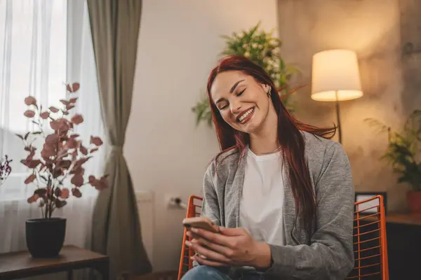 Evde Genç Bir Kadın Cep Telefonu Mesajlaşması Kullanıyor Internette Geziniyor — Stok fotoğraf