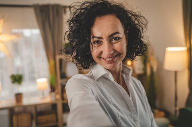 Olgun beyaz kadın beyaz gömlek giyer mutlu bir gülümseme portresi yakın çekim