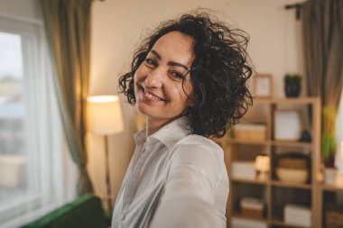 Olgun beyaz kadın beyaz gömlek giyer mutlu bir gülümseme portresi yakın çekim