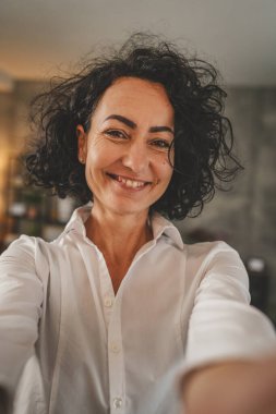 Olgun beyaz kadın beyaz gömlek giyer mutlu bir gülümseme portresi yakın çekim