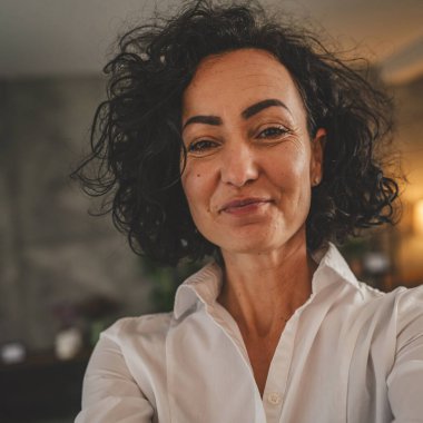 Olgun beyaz kadın beyaz gömlek giyer mutlu bir gülümseme portresi yakın çekim