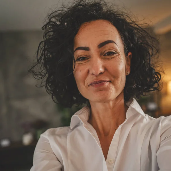 Olgun beyaz kadın beyaz gömlek giyer mutlu bir gülümseme portresi yakın çekim