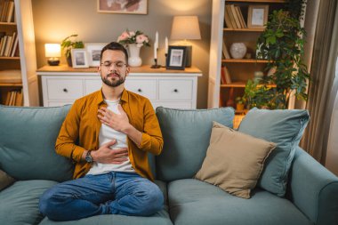 Kafkasyalı erkek, evde meditasyon yoga eğitimi alıyor.